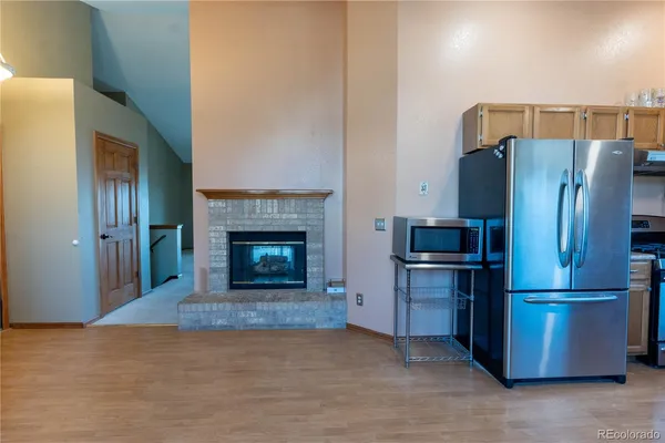 a view of kitchen with refrigerator and fireplace
