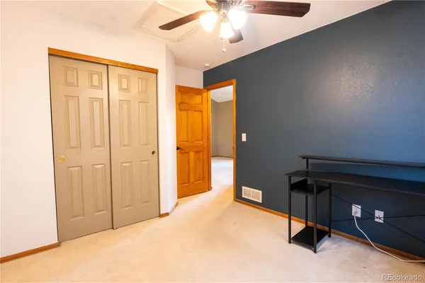 a view of an empty room with closet and workspace