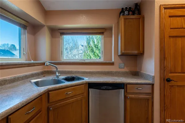 a view of a sink a window and cabinets