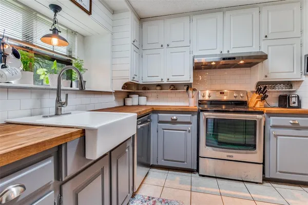 a kitchen with stainless steel appliances granite countertop a sink stove and cabinets