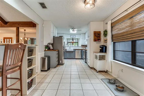 a kitchen with granite countertop a refrigerator and a stove top oven