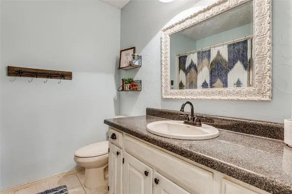 a bath room with a toilet a sink and mirror