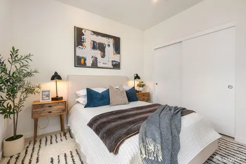 a bedroom with bed and wooden floor
