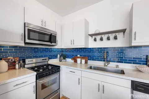 a kitchen with stainless steel appliances a sink stove and microwave