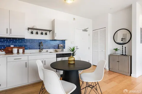 a kitchen with stainless steel appliances granite countertop a sink a stove a dining table and chairs