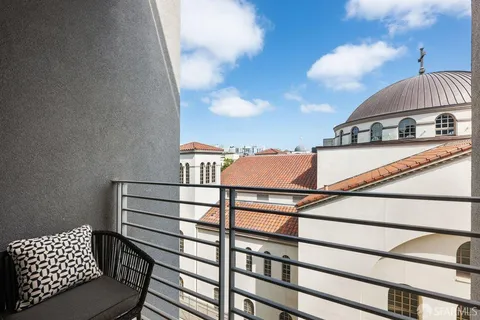 a view of a roof deck with couches and sky view