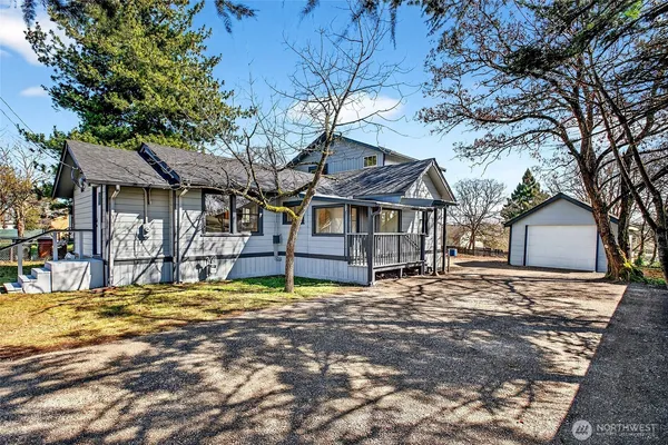 a view of a house with a large tree and a yard
