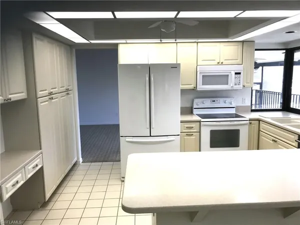 a kitchen with a refrigerator sink and cabinets