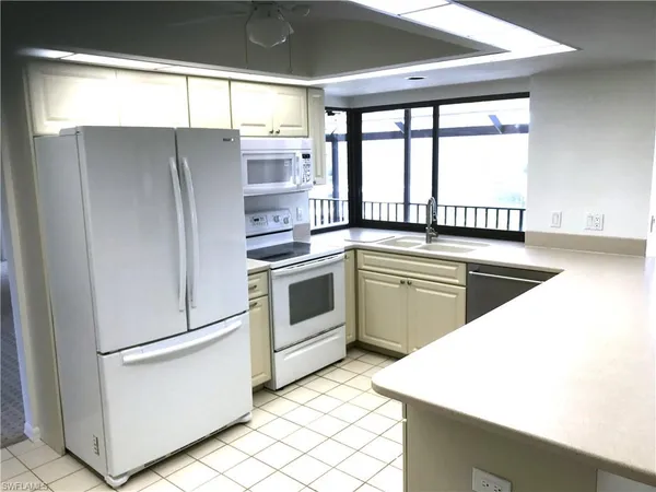 a kitchen with a white cabinets and white appliances