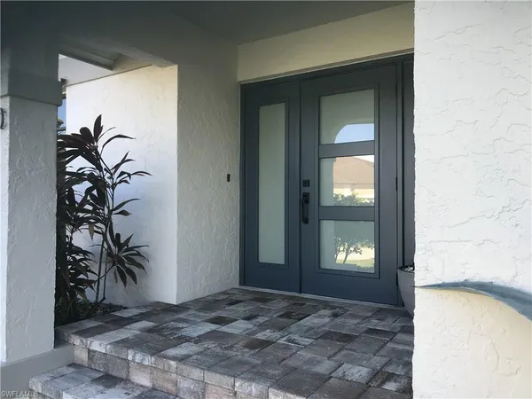 a view of a hallway with wooden floor and a livingroom next to a window