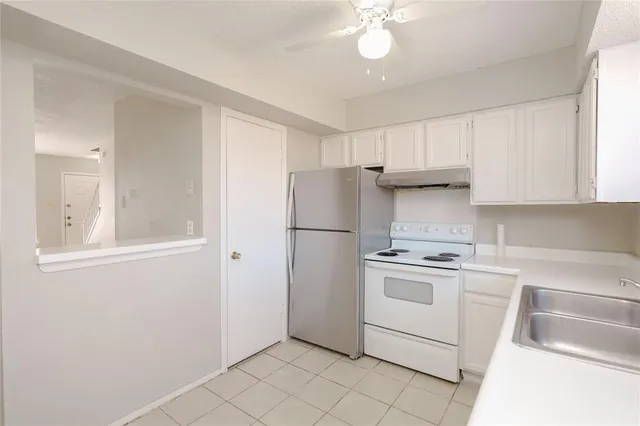 a kitchen with cabinets stainless steel appliances and a window