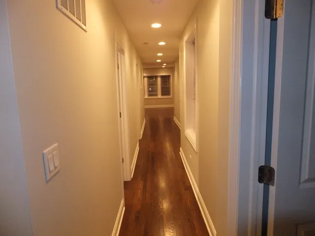 a view of a hallway with wooden floor and staircase