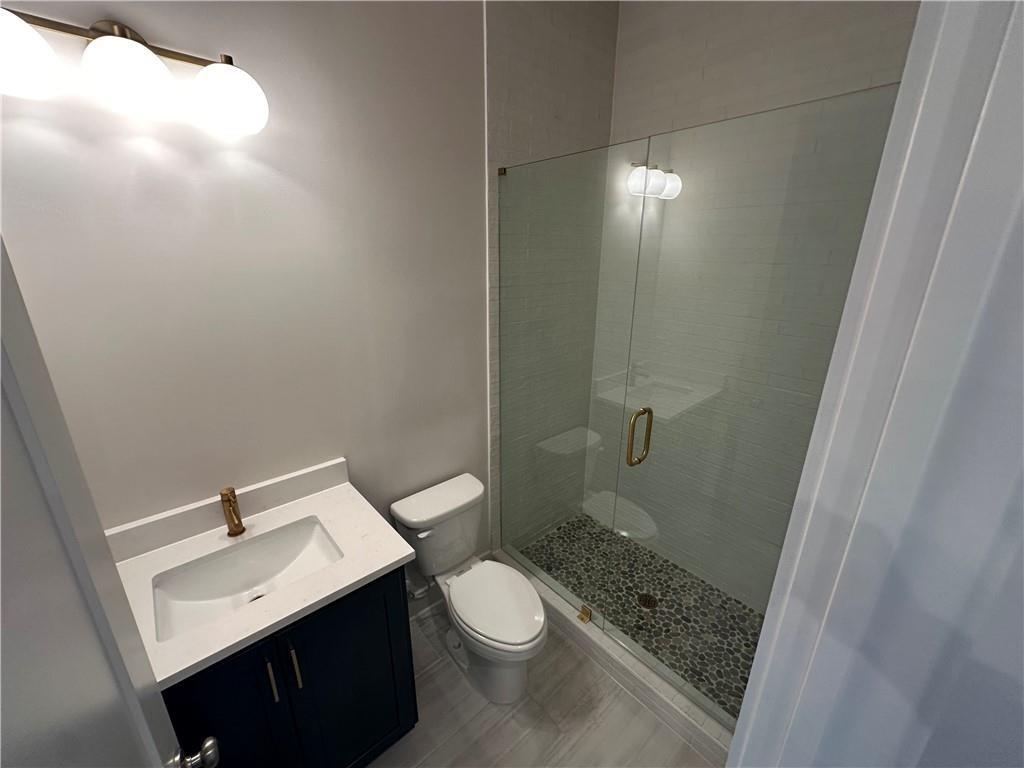 962 Bibb Street Northwest, Unit 6 Atlanta, GA 30318 - Photo 7 of 14 a bathroom with a sink a toilet a mirror and shower