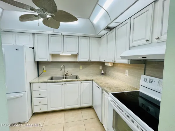 a kitchen with kitchen island granite countertop a sink stainless steel appliances and cabinets