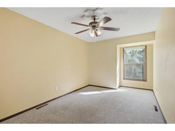 a view of an empty room with chandelier fan and a table
