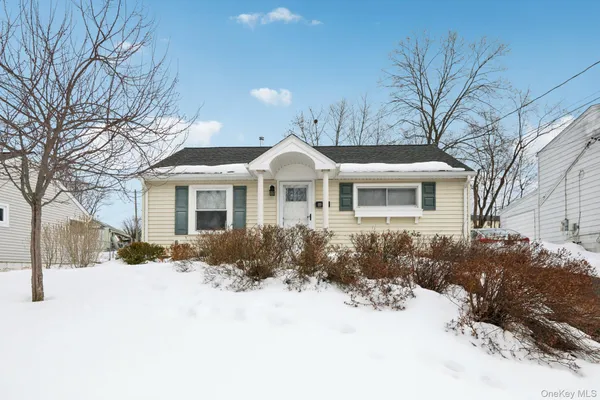 a front view of a house with a yard covered in snow