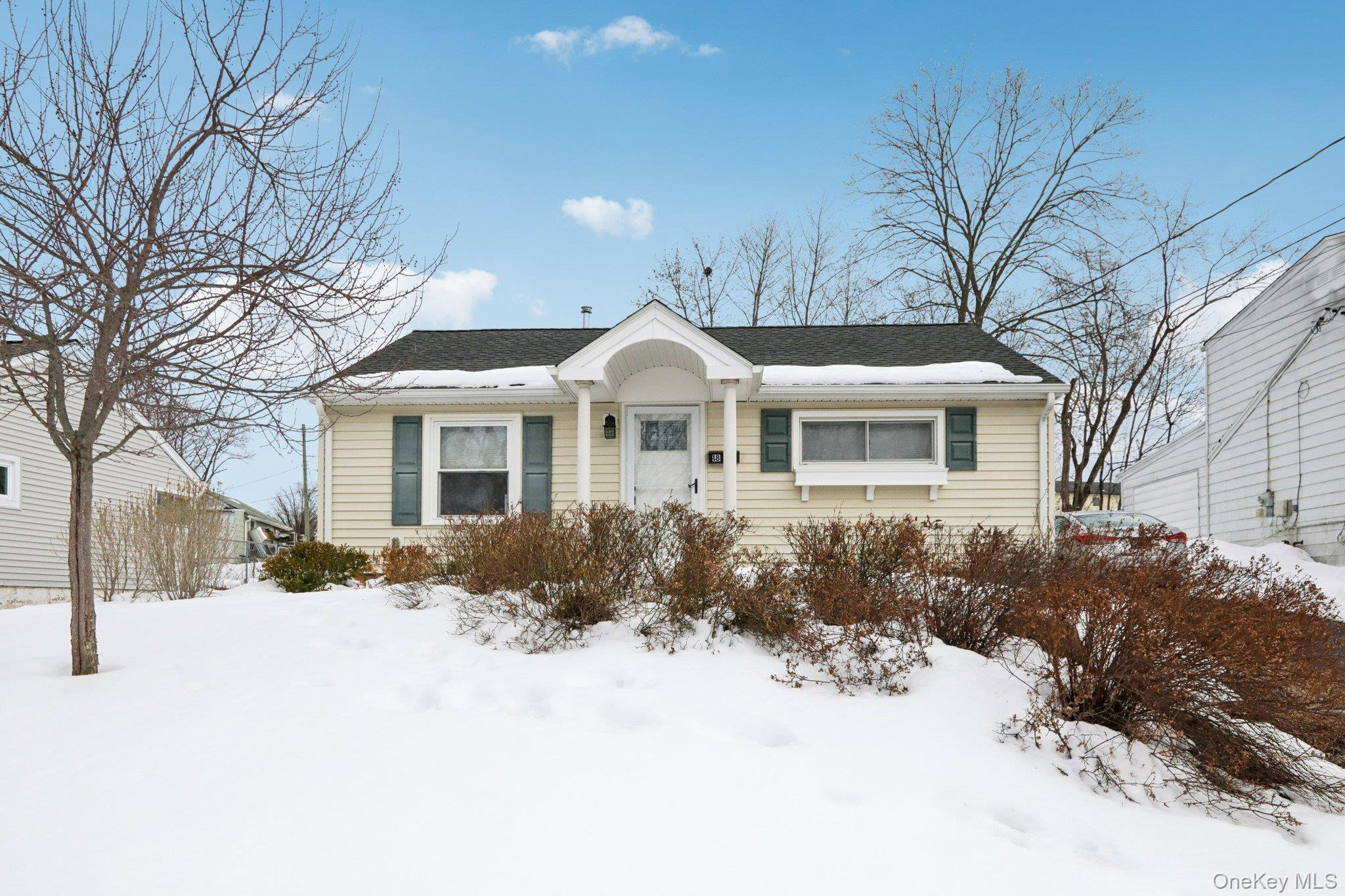 a front view of a house with a yard covered in snow