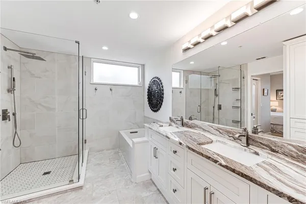a bathroom with a double vanity sink mirror double and shower