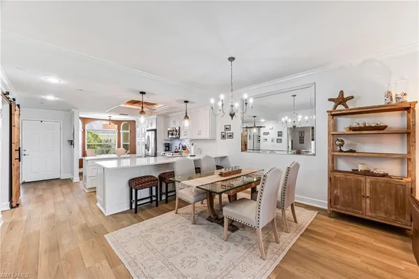 a living room with furniture a fireplace and a chandelier