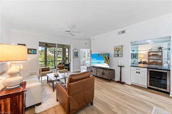a living room with furniture a flat screen tv and a large window