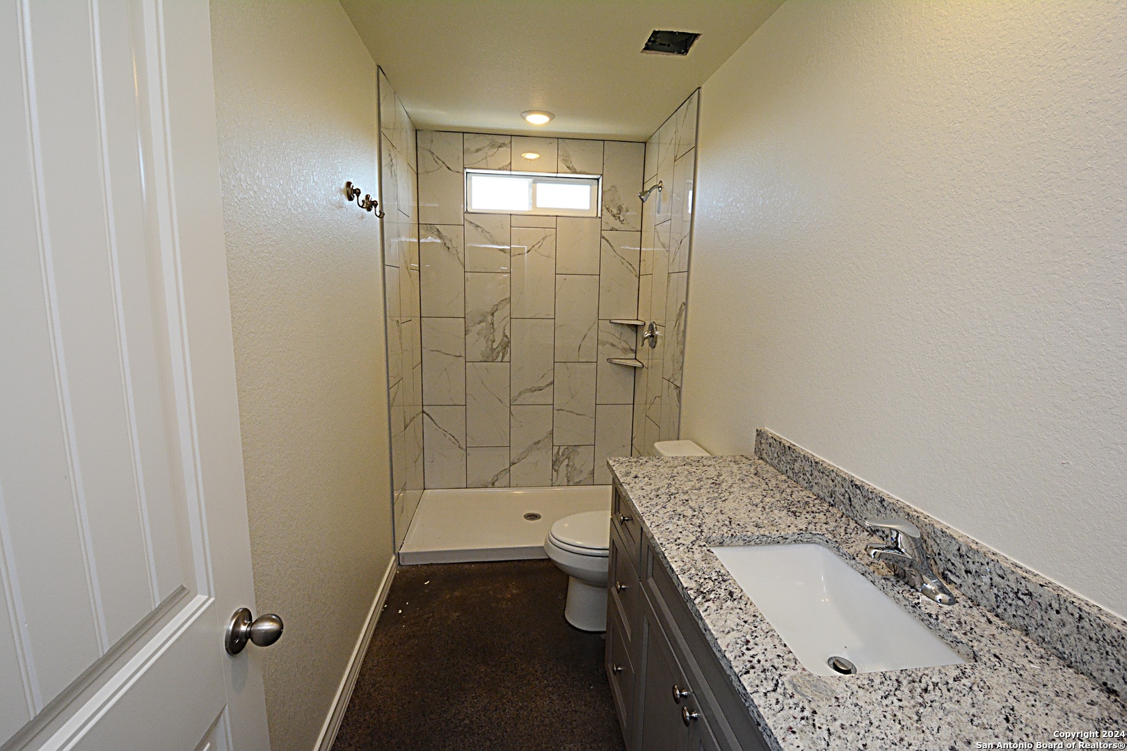 1559 Golf Course Drive Spring Branch, TX 78070 - Photo 5 of 8 a bathroom with a granite countertop sink a toilet and shower