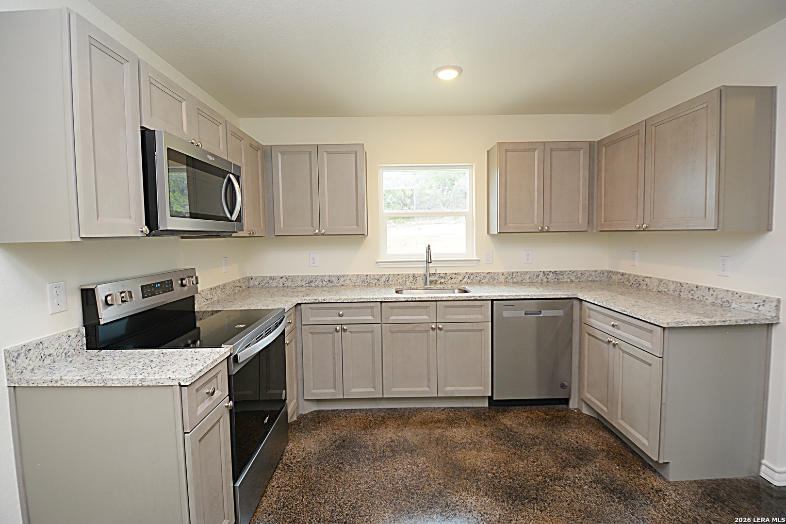 1559 Golf Course Drive Spring Branch, TX 78070 - Photo 7 of 15 a kitchen with granite countertop a sink stove and microwave