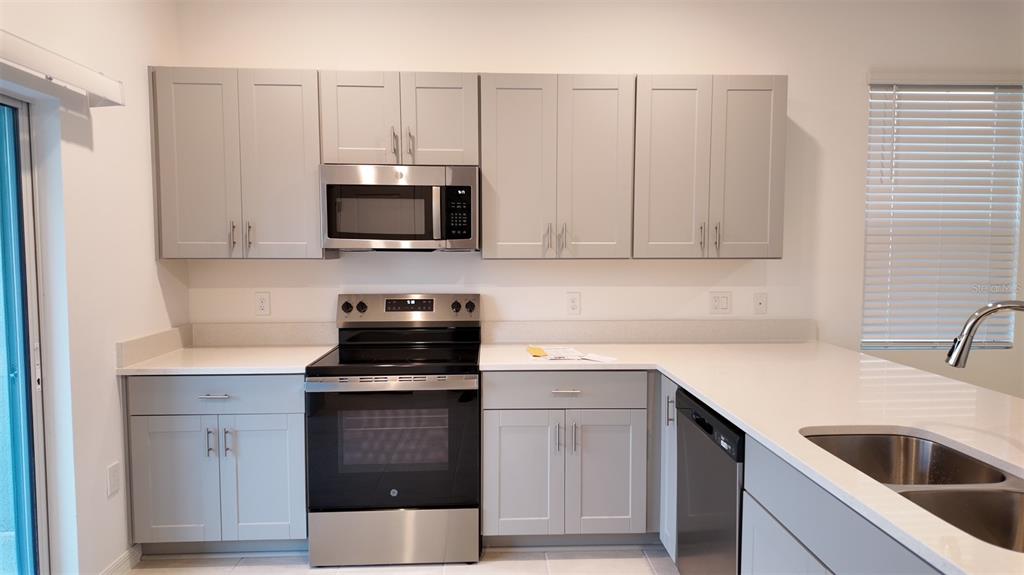 3240 Skyline Loop Kissimmee, FL 34758 - Photo 3 of 26 a kitchen with cabinets stainless steel appliances and cabinets