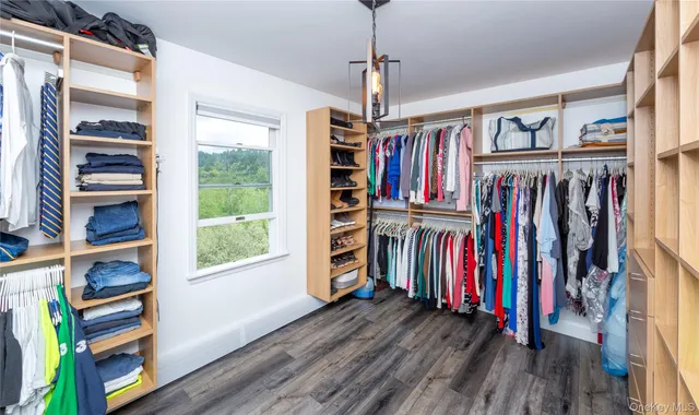 a view of walk in closet with clothes and shoes