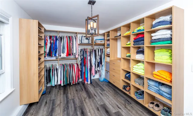 a view of walk in closet with clothes and shoes