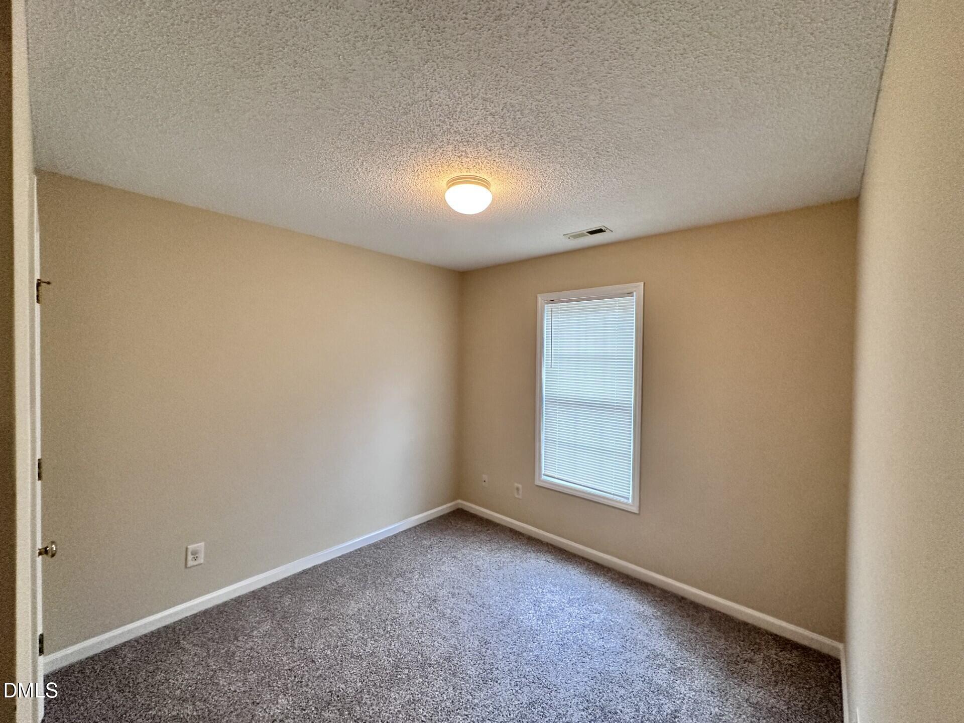 2112 Walnut Bluffs Lane Raleigh, NC 27610 - Photo 17 of 18 an empty room with a empty space and windows