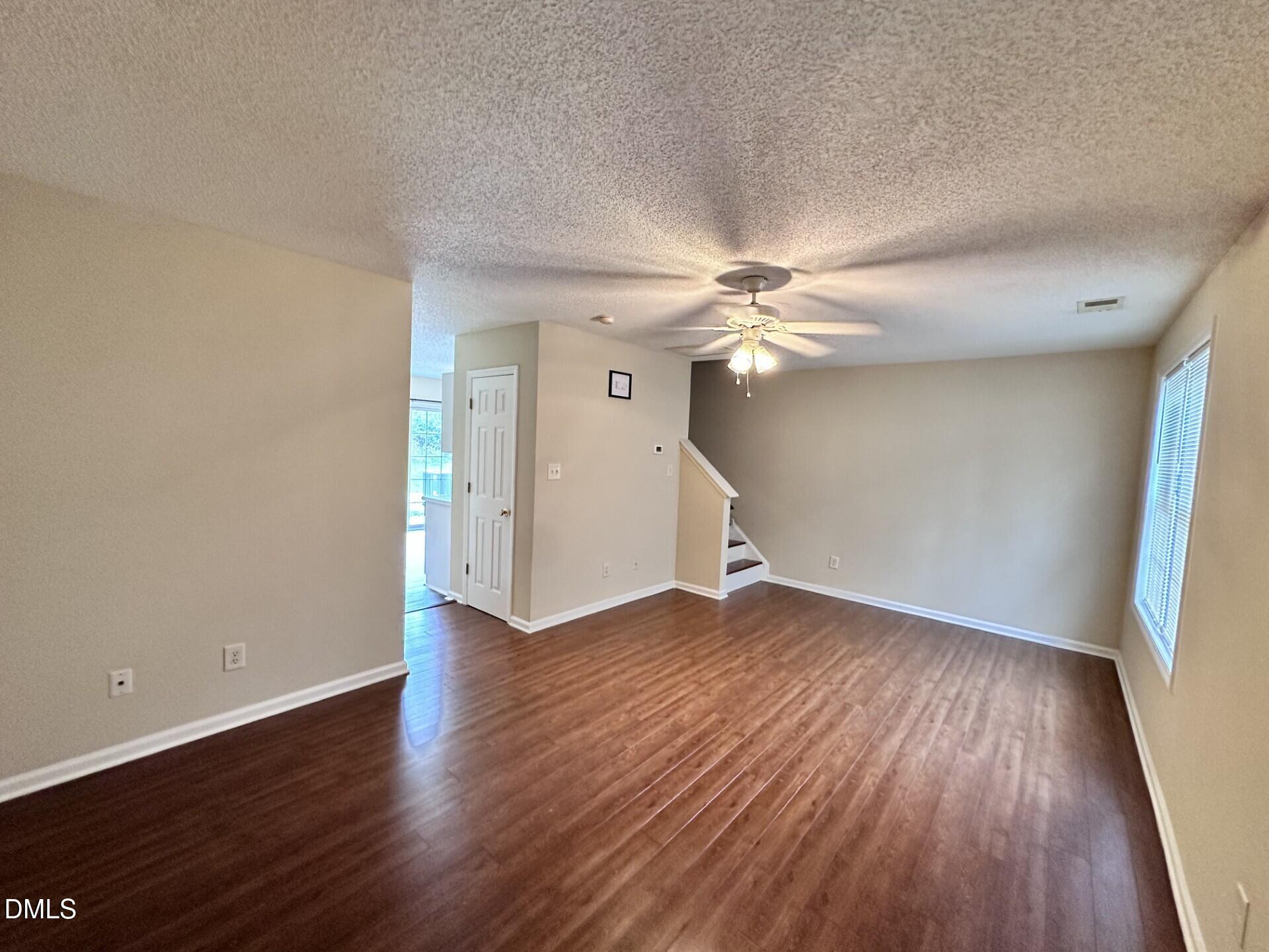 2112 Walnut Bluffs Lane Raleigh, NC 27610 - Photo 2 of 18 an empty room with wooden floor fan and windows