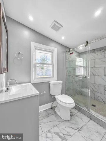 a bathroom with a toilet sink and a mirror