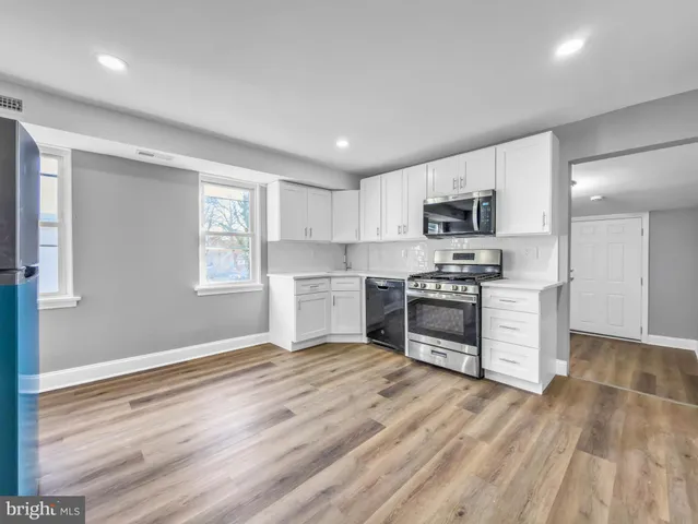 a kitchen with granite countertop white cabinets and stainless steel appliances