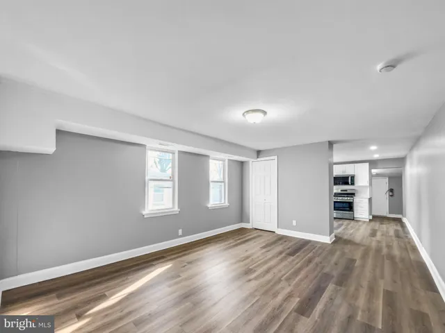 a view of empty room with wooden floor and window