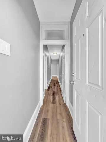 a view of a hallway with wooden floor and staircase