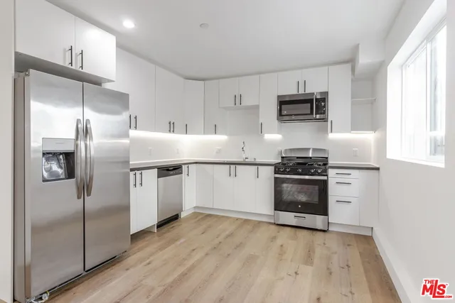 a kitchen with stainless steel appliances a refrigerator sink and stove