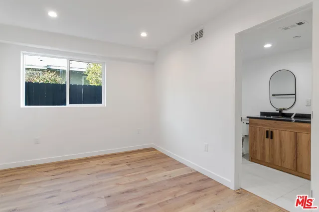 a view of a kitchen with wooden floor and a window