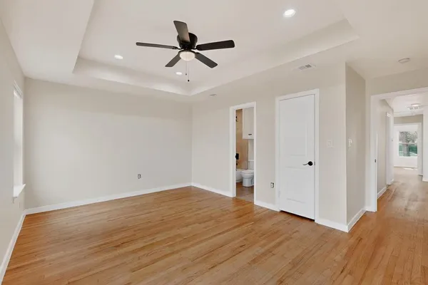 a view of a big room with wooden floor a ceiling fan