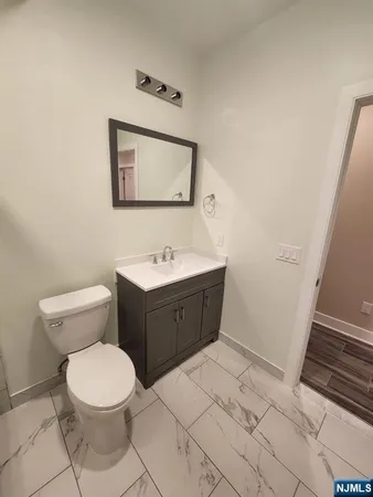 a bathroom with a toilet sink and mirror