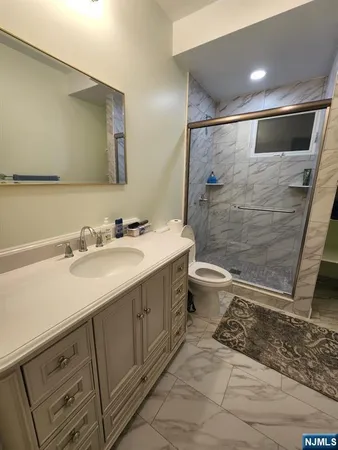 a bathroom with a double vanity sink toilet and shower