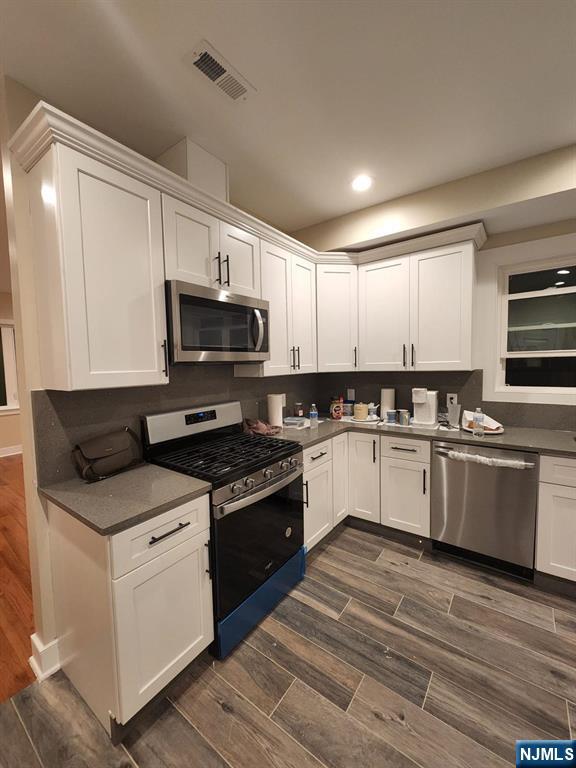 229 East 24th Street, Unit 1 Paterson, NJ 07514 - Photo 19 of 19 a kitchen with granite countertop white cabinets and white appliances