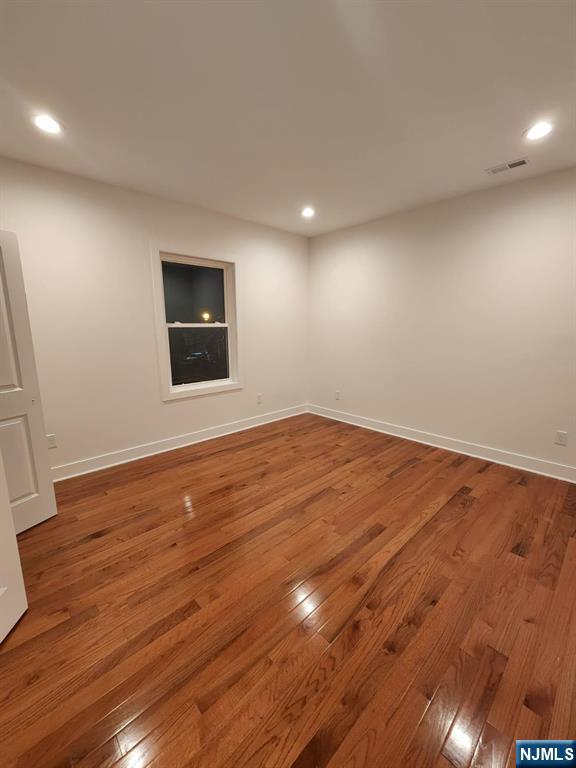 229 East 24th Street, Unit 1 Paterson, NJ 07514 - Photo 3 of 19 an empty room with wooden floor and windows
