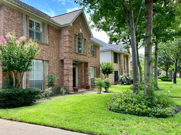 a front view of a house with a yard and trees