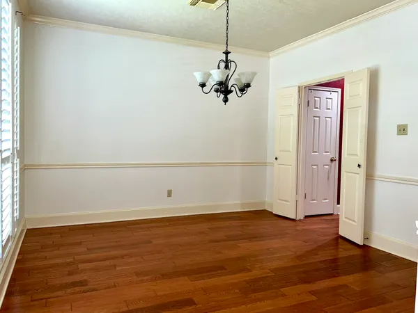 a view of a room with wooden floor and white walls