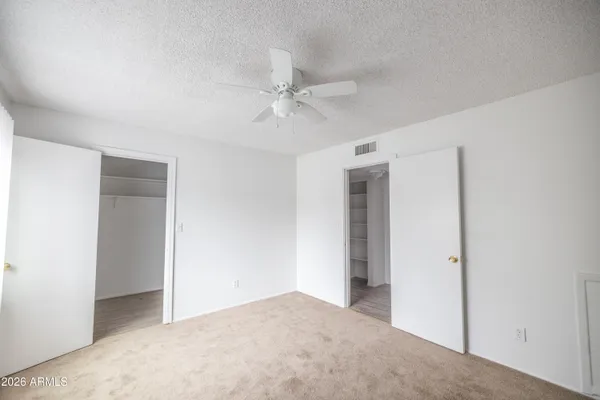 a view of an empty room with a ceiling fan