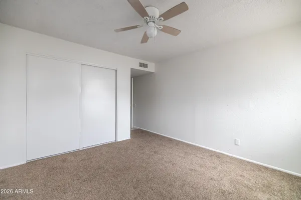 an empty room with a ceiling fan and a ceiling fan