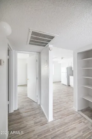 a view of empty room with wooden floor