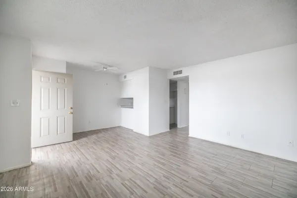 a view of an empty room with wooden floor