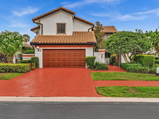 a front view of a house with a yard and potted plants