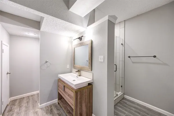 a bathroom with a sink and mirror with shower
